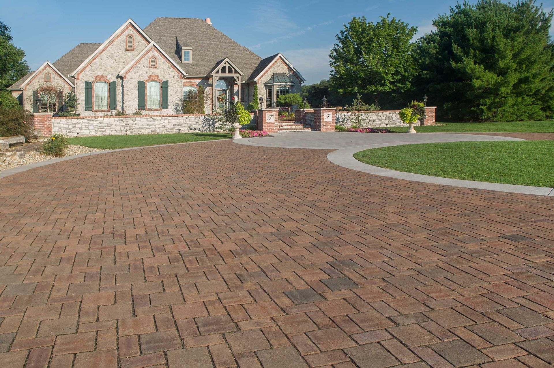 A large house with a brick driveway in front of it