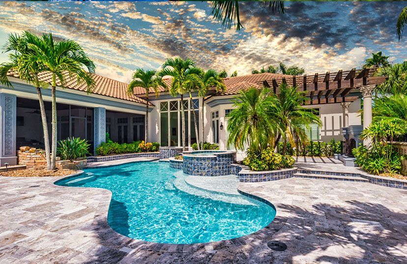 A large house with a large swimming pool in the backyard surrounded by palm trees.
