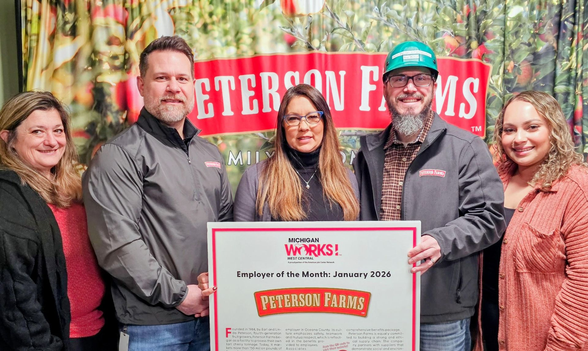 Five people holding a Employer of the Month posterboard for Peterson Farms.