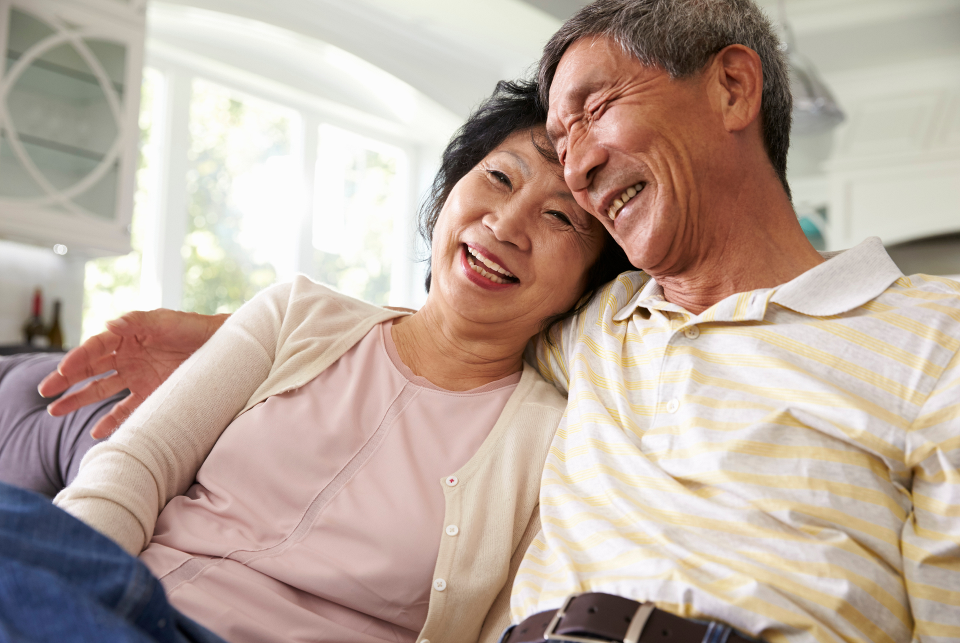 A man and a woman are sitting on a couch talking to a counselor.