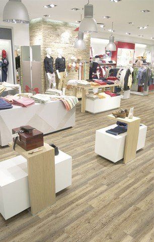 Ein Bekleidungsgeschäft mit Holzboden und Tischen.