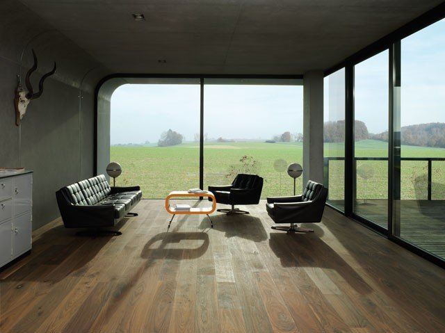 Ein Wohnzimmer mit Couch und Stühlen und einem großen Fenster