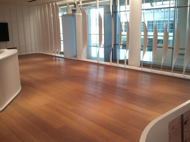 Ein leerer Raum mit Holzboden und weißen Wänden