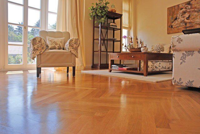 Ein Wohnzimmer mit Holzboden, einem Stuhl, einem Couchtisch und einem Gemälde an der Wand.