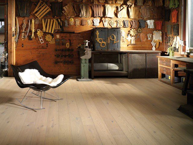 In einem Raum mit Holzboden steht ein Stuhl.