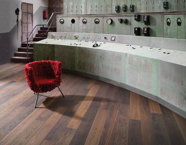 Ein roter Stuhl steht auf einem Holzboden in einem Zimmer