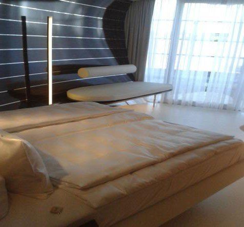 Ein Hotelzimmer mit einem großen Bett und einer Bank