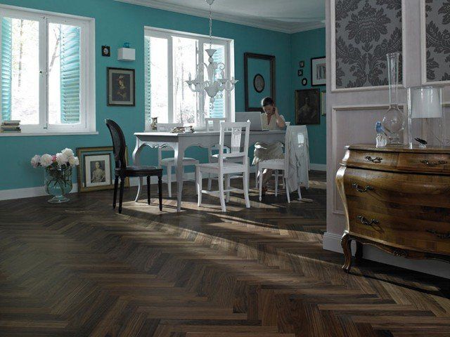 Eine Frau sitzt an einem Tisch in einem Wohnzimmer mit blauen Wänden.