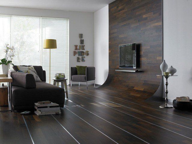 Ein Wohnzimmer mit einer Couch, einem Sessel und einem Fernseher