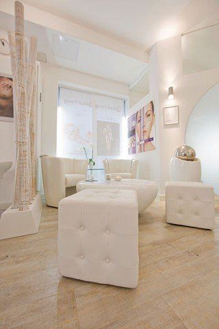 Ein Wohnzimmer mit weißen Möbeln und Holzboden.