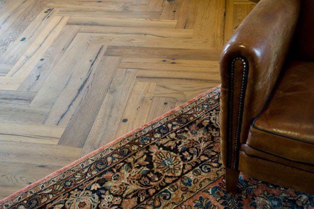 Ein Stuhl steht auf einem Teppich neben einem Holzboden.