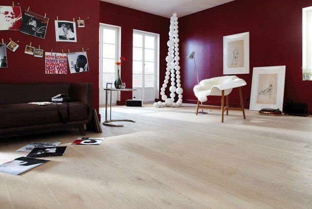 Ein Wohnzimmer mit roten Wänden und Holzboden
