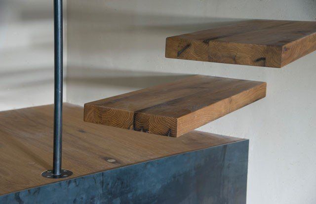 Eine Nahaufnahme einer Holztreppe mit einem Metallgeländer.