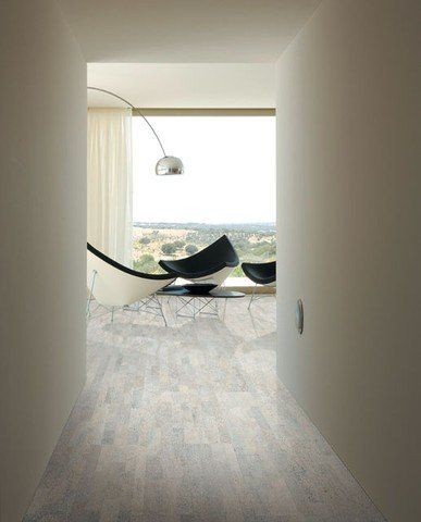 Ein Flur führt zu einem Wohnzimmer mit Stühlen und einem großen Fenster.