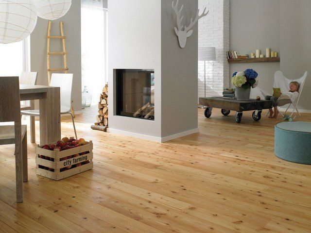 Ein Wohnzimmer mit Holzboden und Kamin