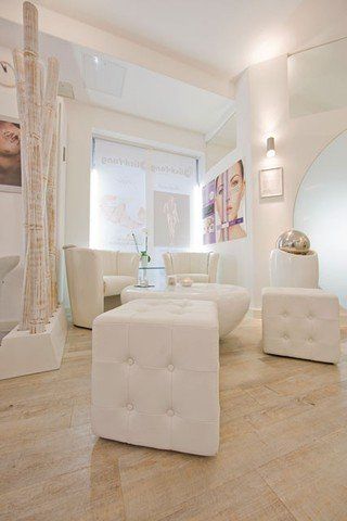 Ein Wohnzimmer mit weißen Möbeln und Holzboden.