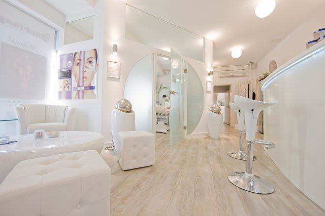 Ein weißer Raum mit vielen Möbeln und einem Barhocker.