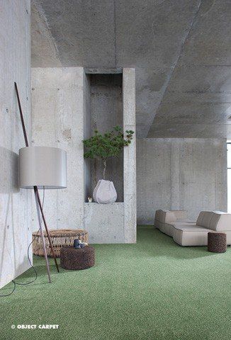 Ein Wohnzimmer mit einem Sofa, einer Lampe und einem grünen Teppich.