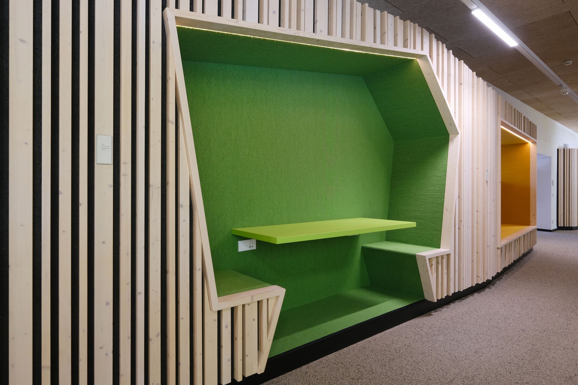 Eine Holzwand mit einem grünen Regal in der Mitte.