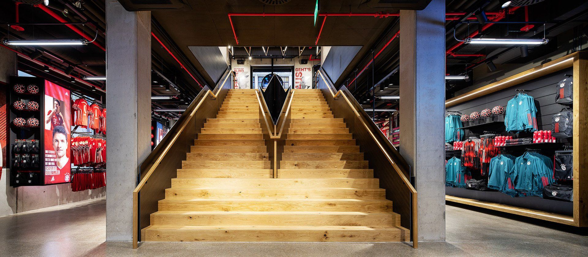 Eine Person geht in einem Geschäft eine Holztreppe hinauf.