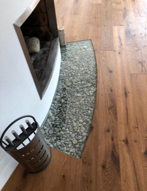 Ein Holzboden mit einem Kamin im Hintergrund