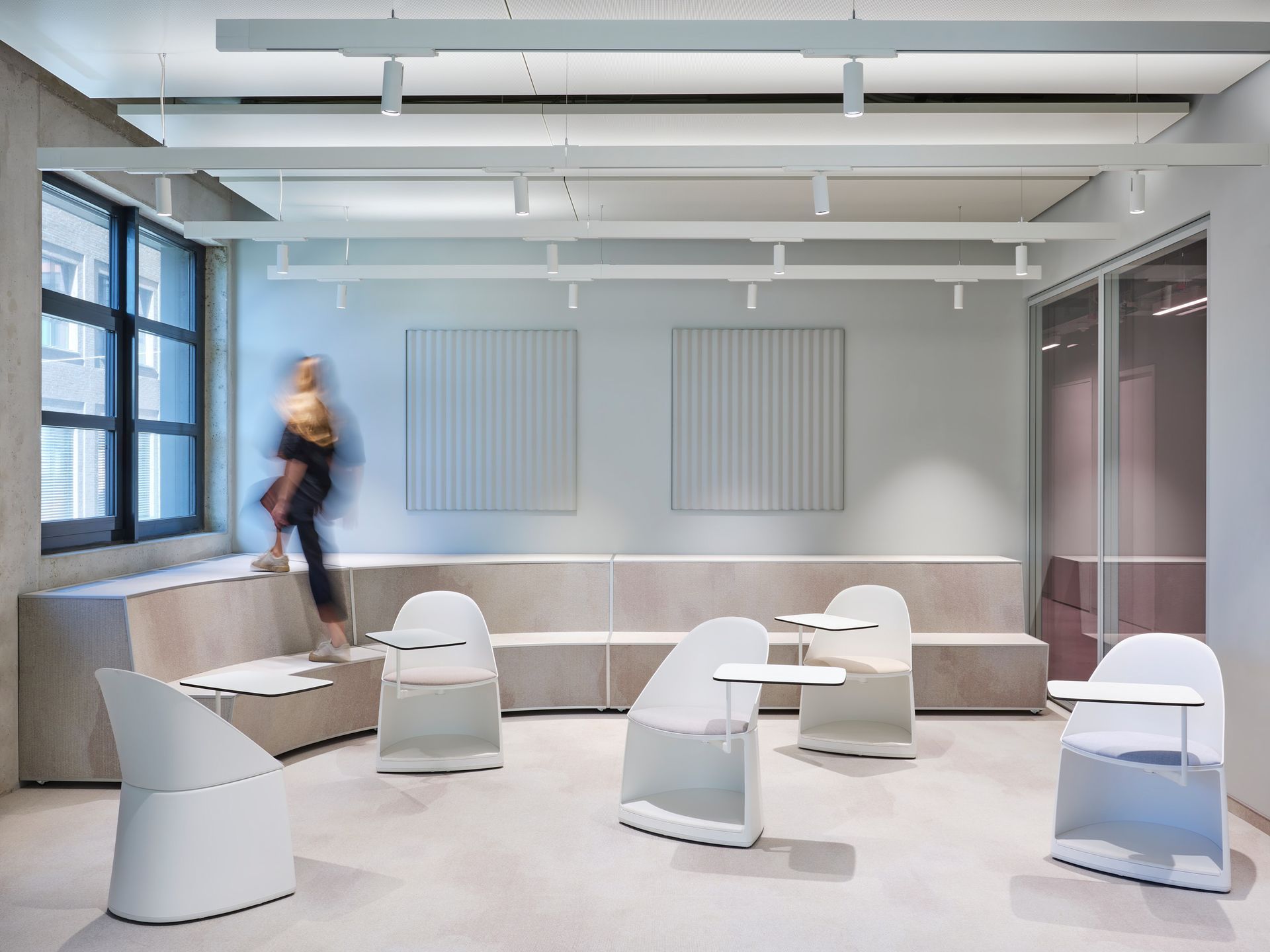 Eine Frau geht in einen Raum mit Stühlen und Tischen.