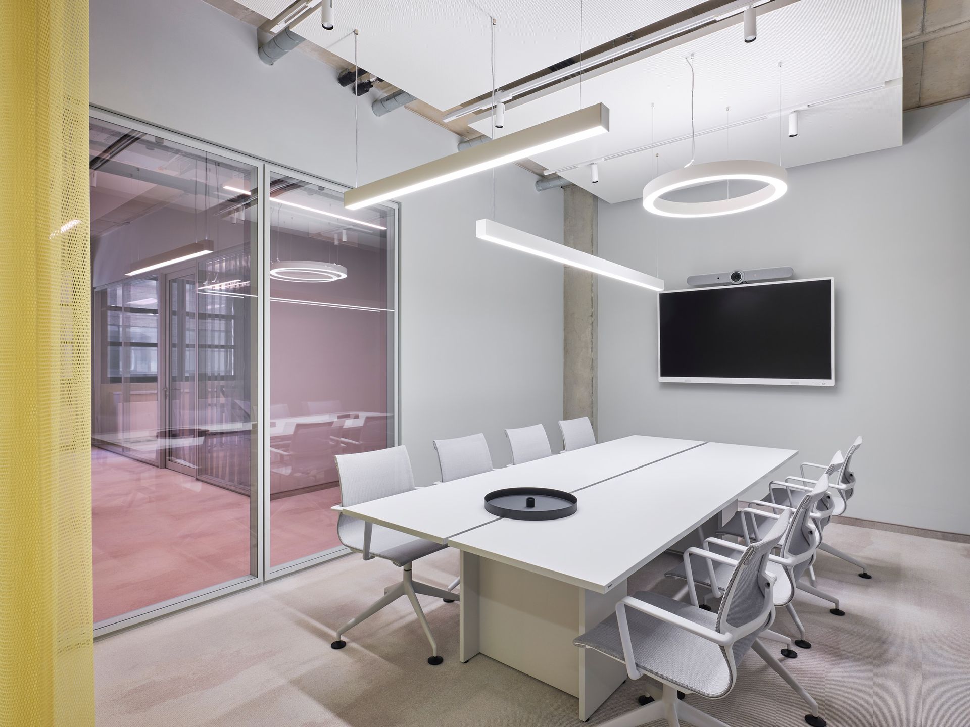 Ein Konferenzraum mit einem langen weißen Tisch und Stühlen.