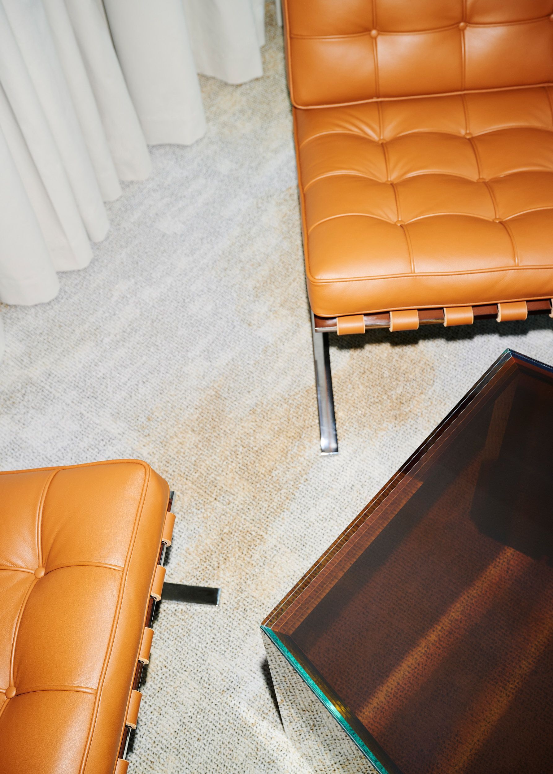 Ein Wohnzimmer mit einem braunen Ledersessel und einem Couchtisch aus Glas