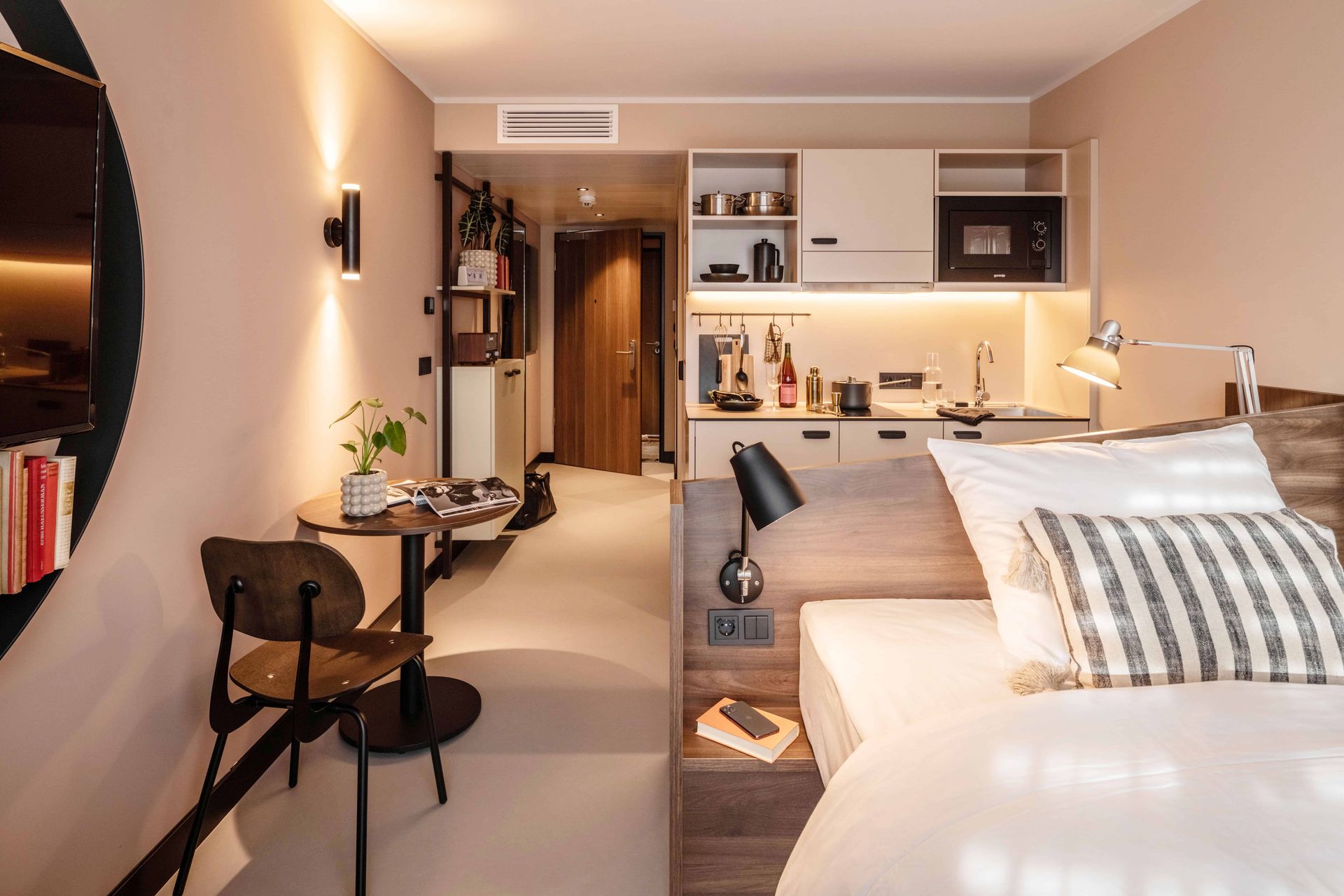 Ein Hotelzimmer mit Bett, Stuhl, Tisch und Küche.