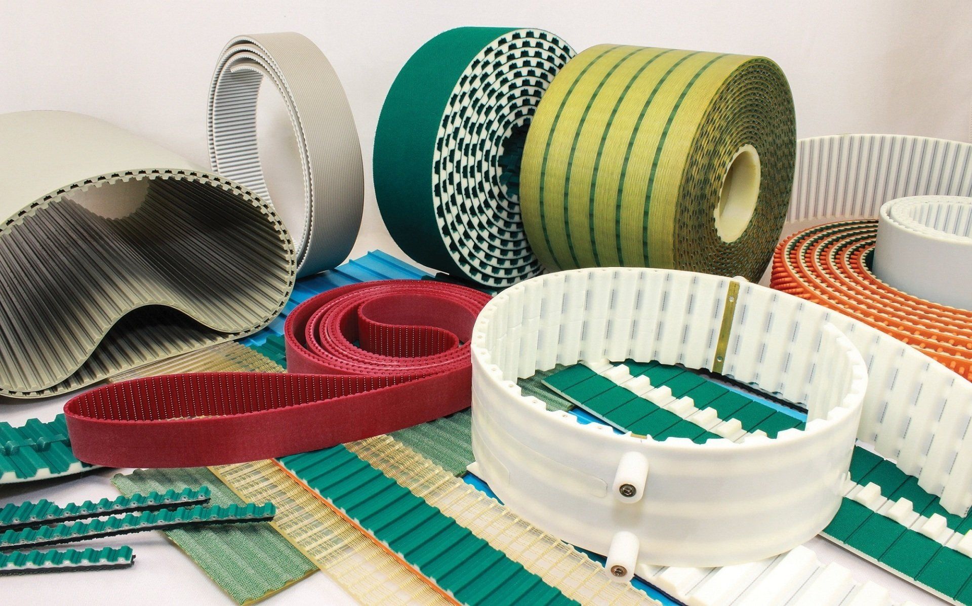 Varias correas de transmisión industriales en diferentes colores y patrones.