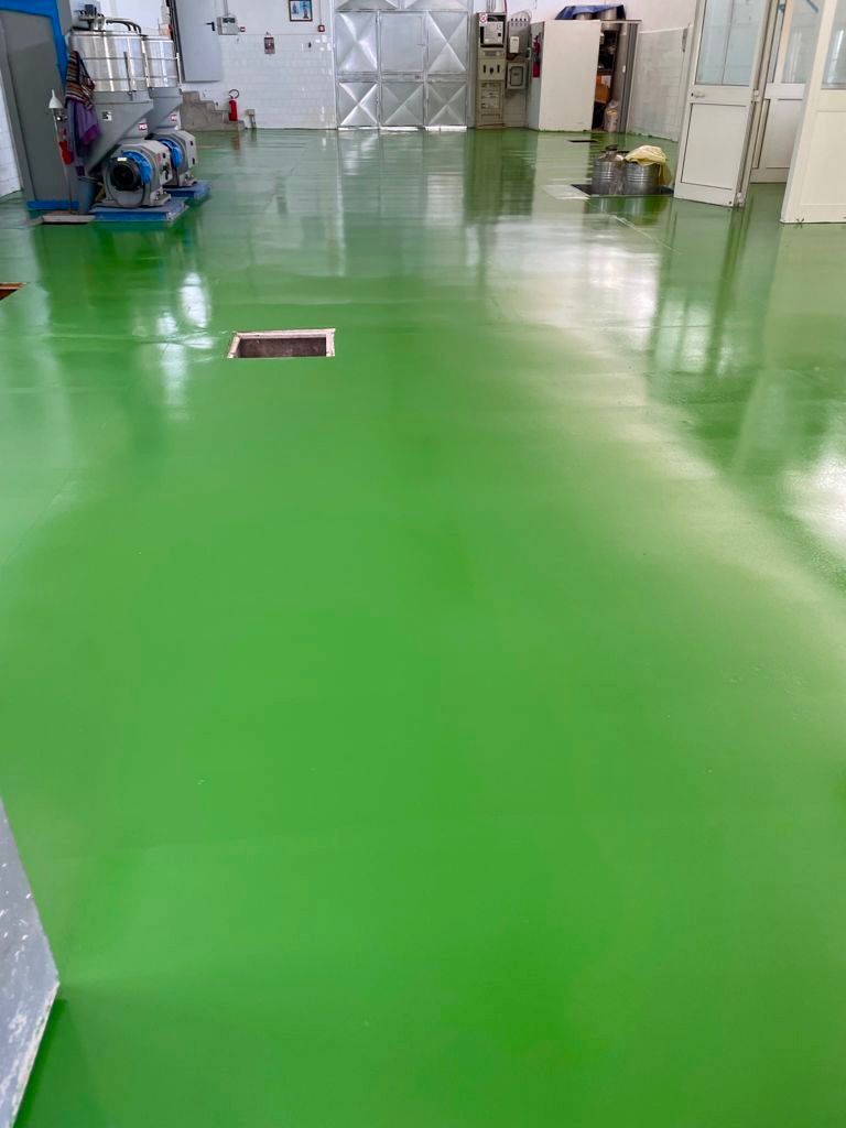 Un pavimento verde in una stanza con molti mobili.