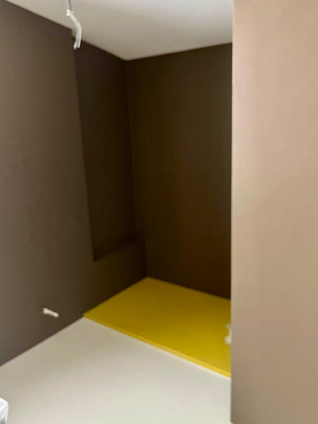 Un bagno con pareti marroni e pavimento giallo.