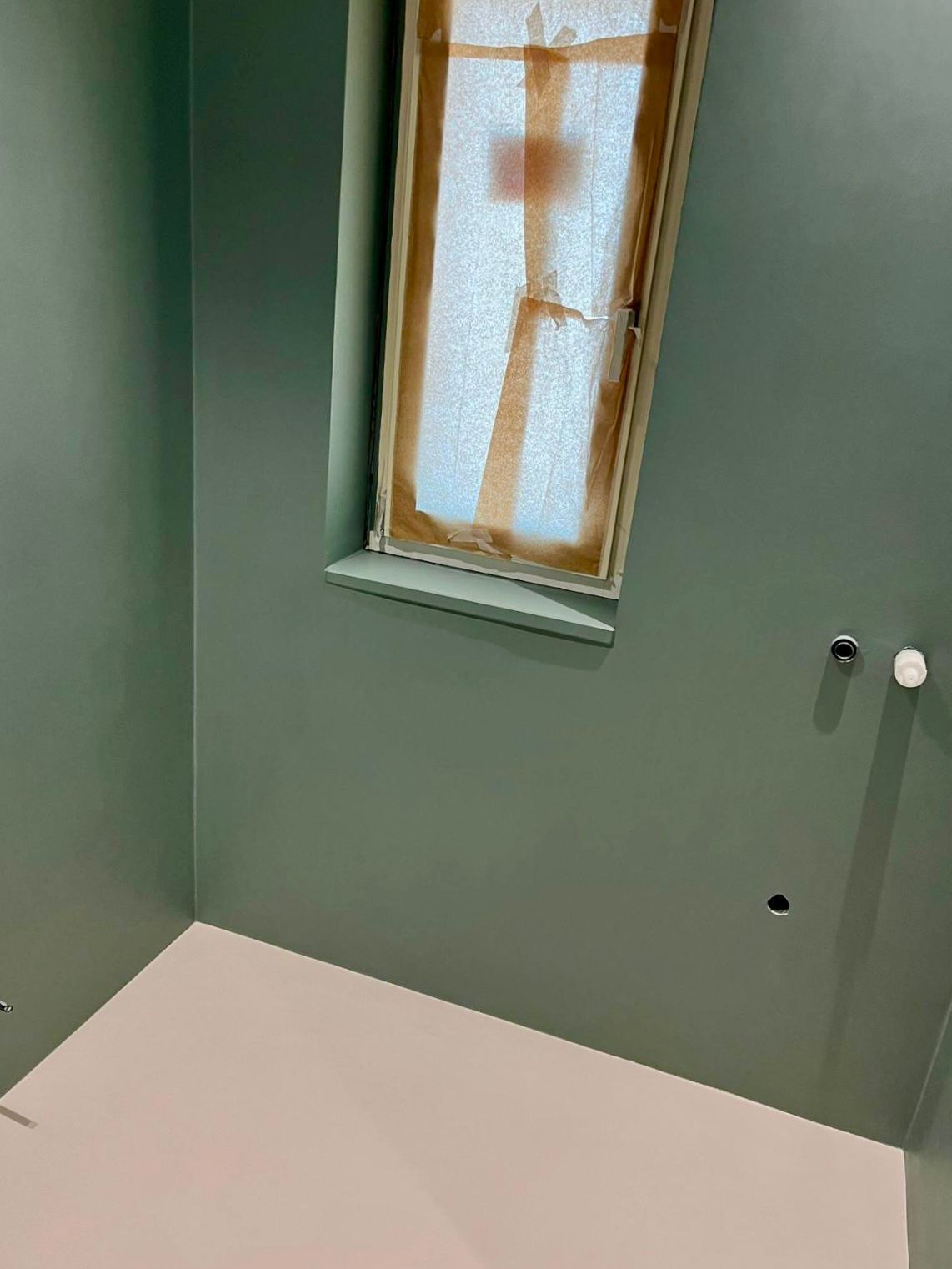 Un bagno con finestra e pavimento rosa.