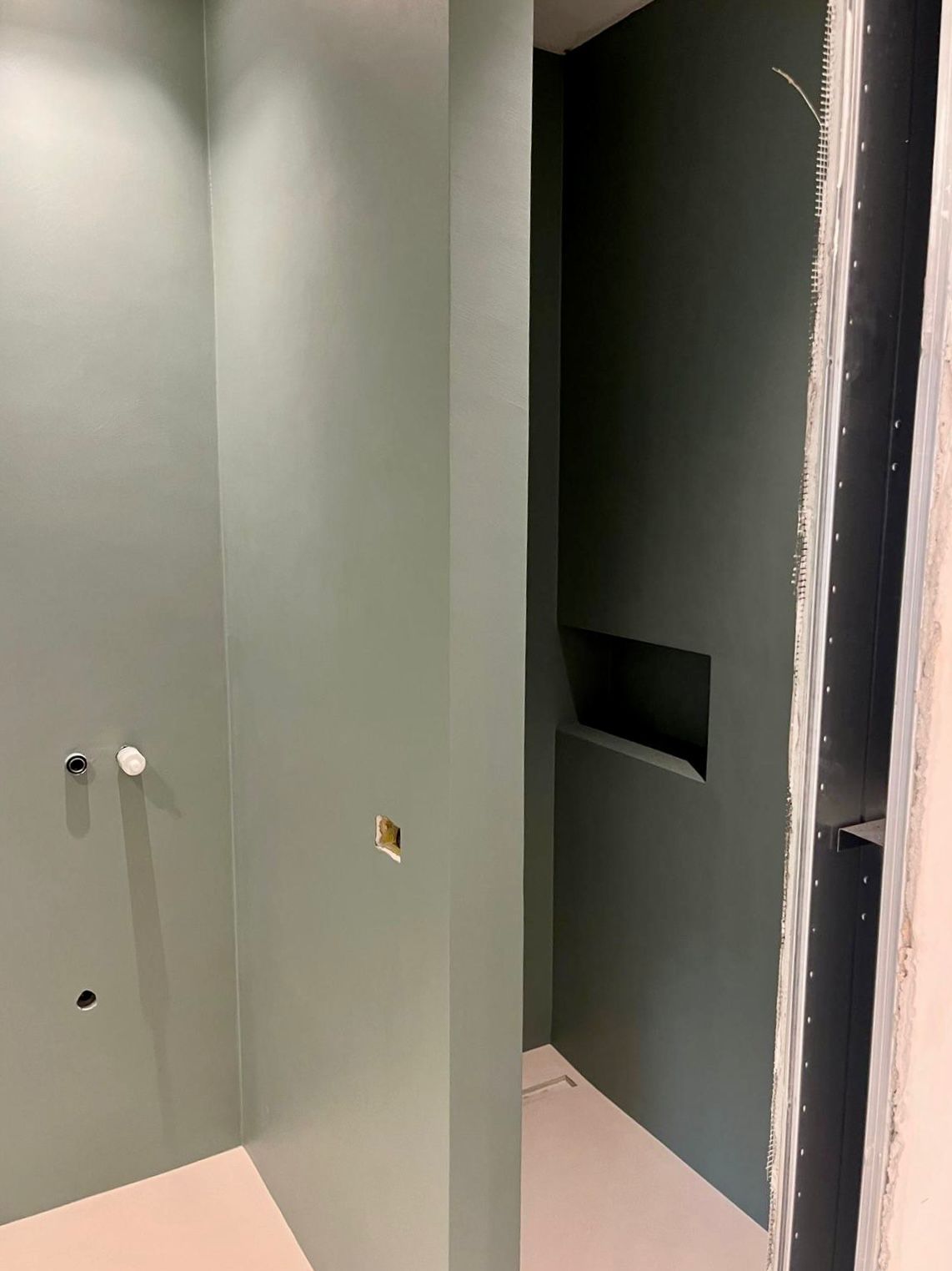 Un bagno con pareti verdi e pavimento rosa.