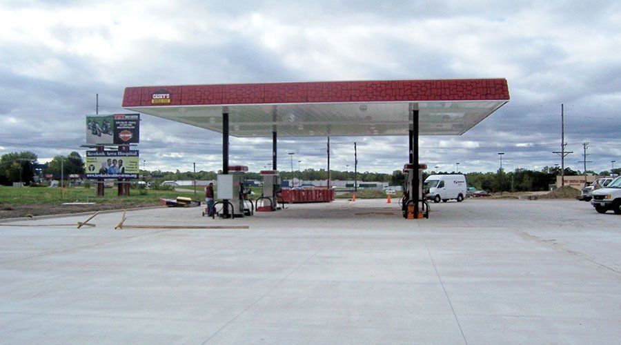 A commercial concrete parking lot near a gas station.