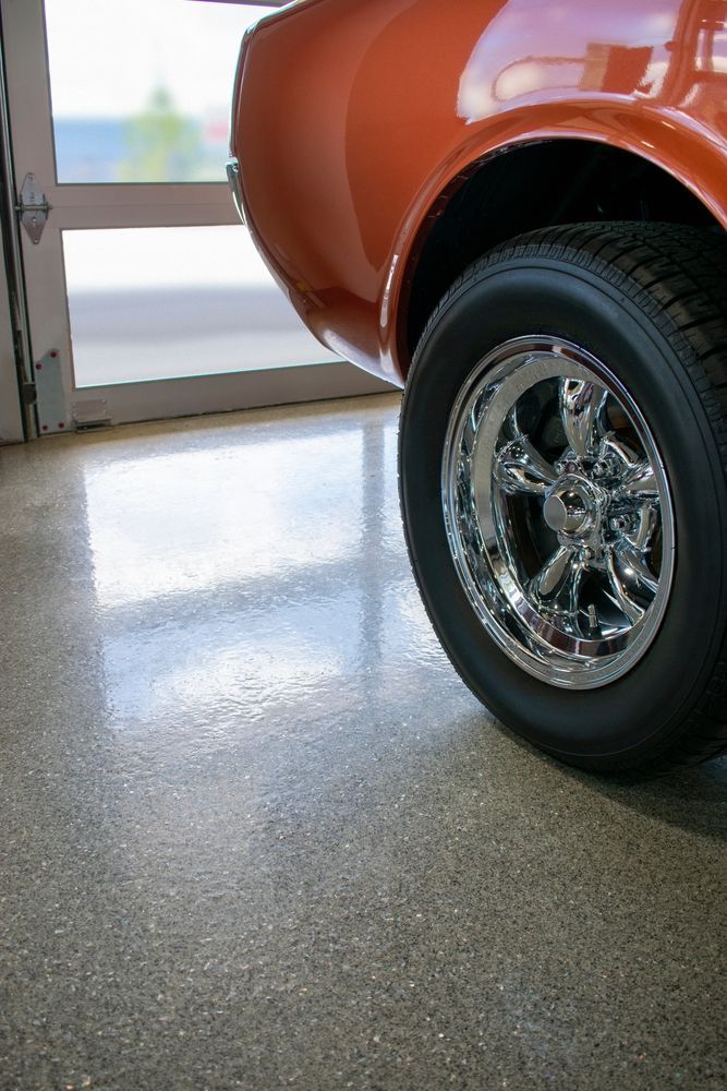 A close up of a car wheel on a shiny floor.