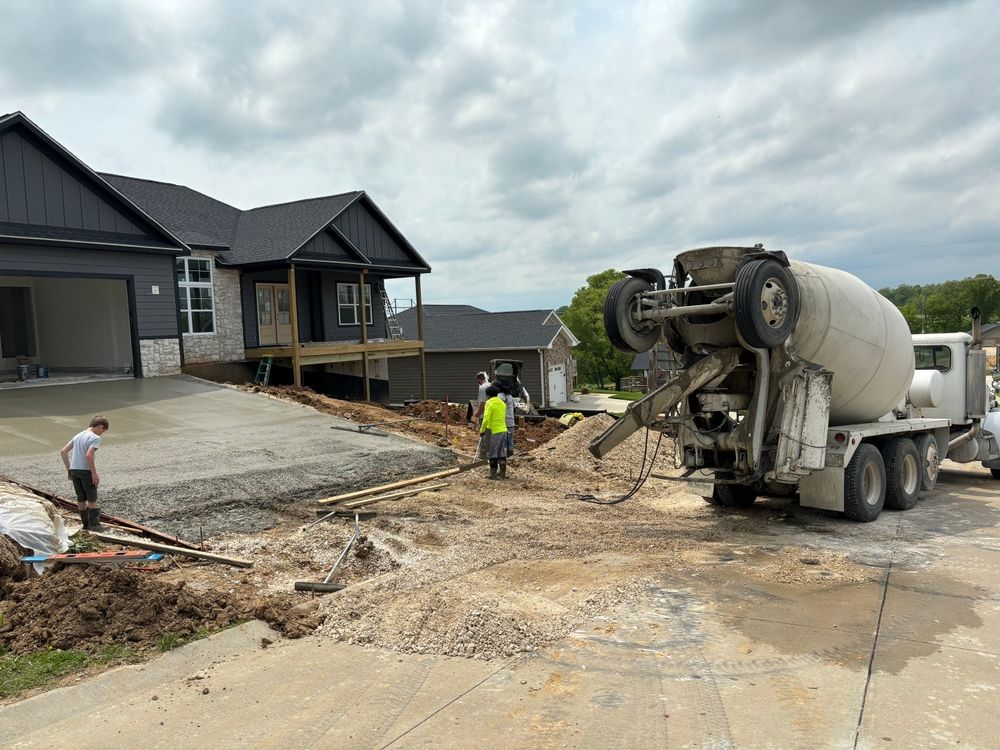 Workers are replacing a concrete driveway.