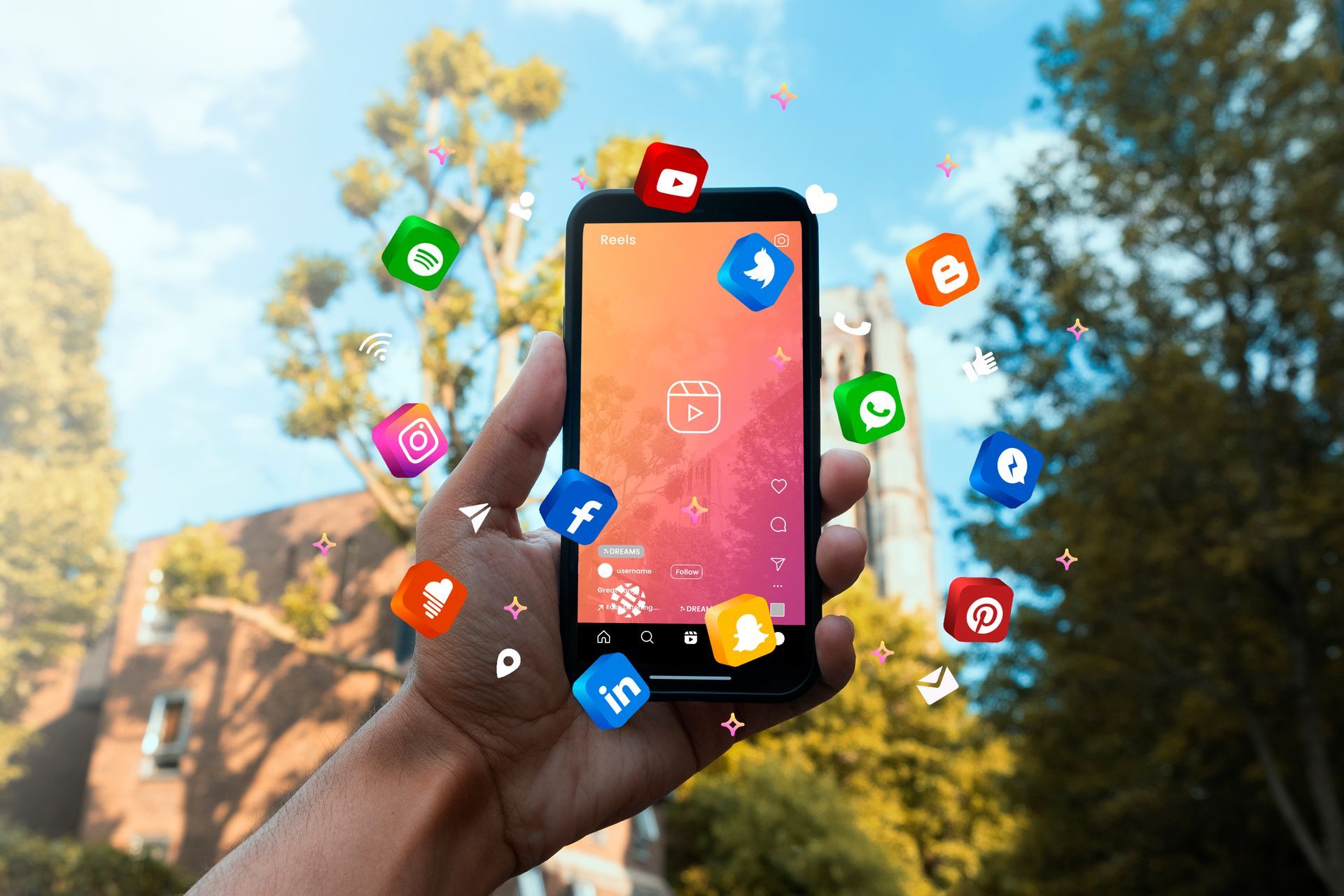 Une main tient un téléphone portable avec des icônes de médias sociaux volant autour d'elle.