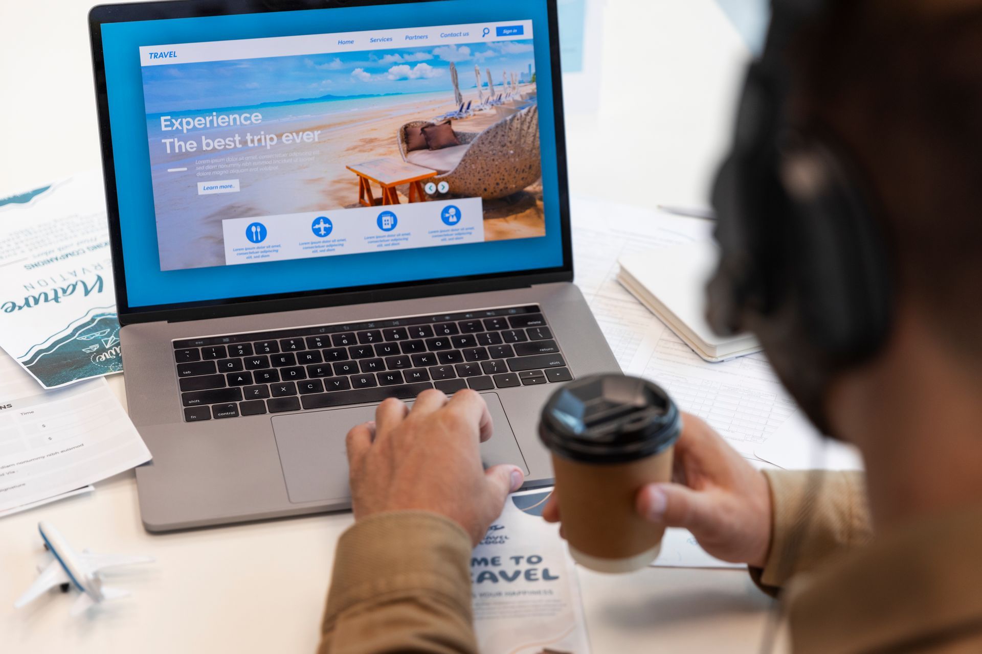 Un homme utilise un ordinateur portable tout en tenant une tasse de café.