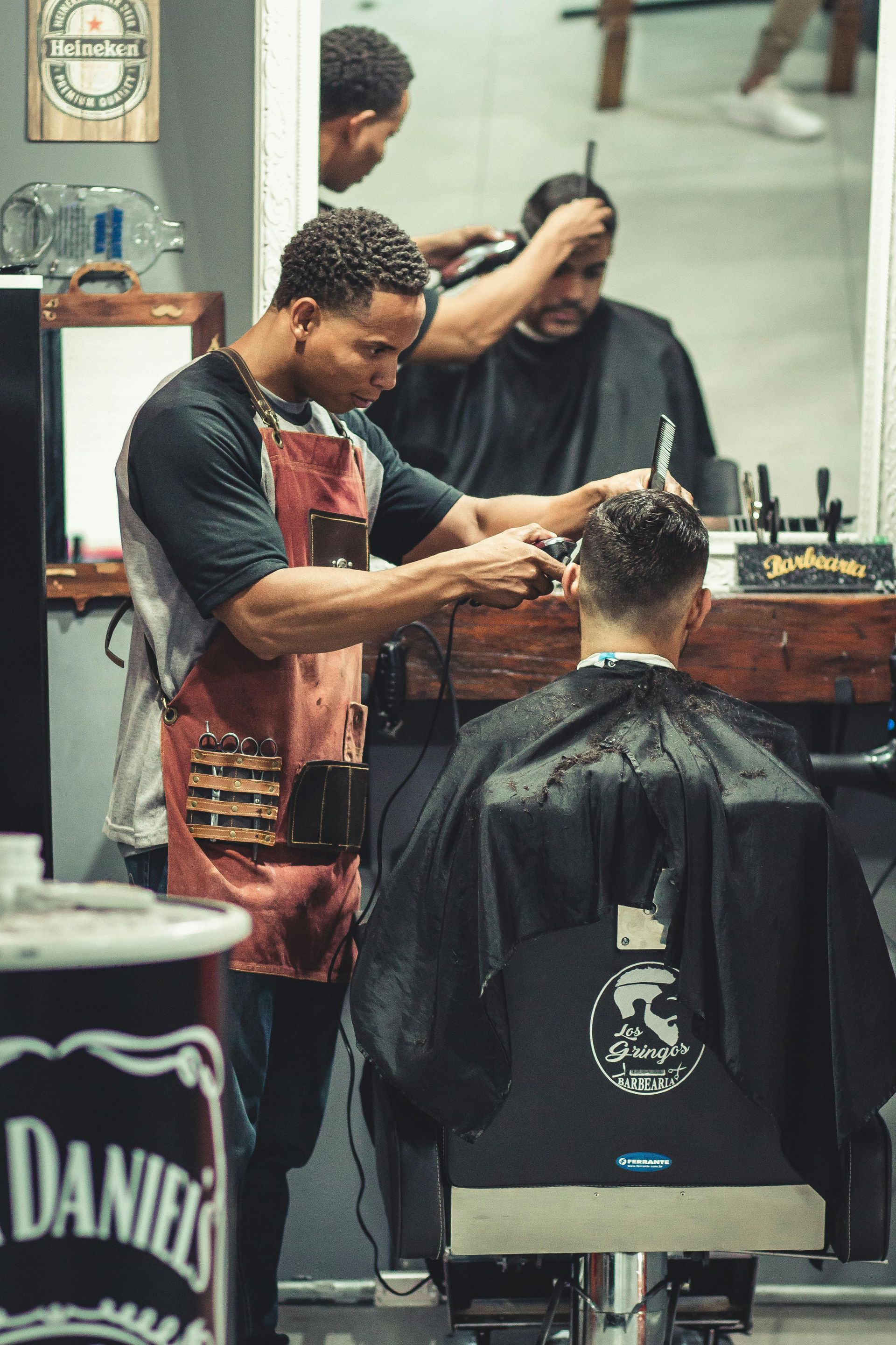 Un homme se fait couper les cheveux par un coiffeur dans un salon de coiffure.