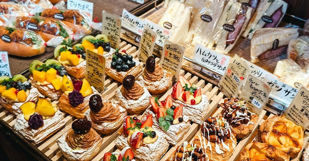 Une variété de pâtisseries et de sandwichs sont exposés dans une boulangerie.