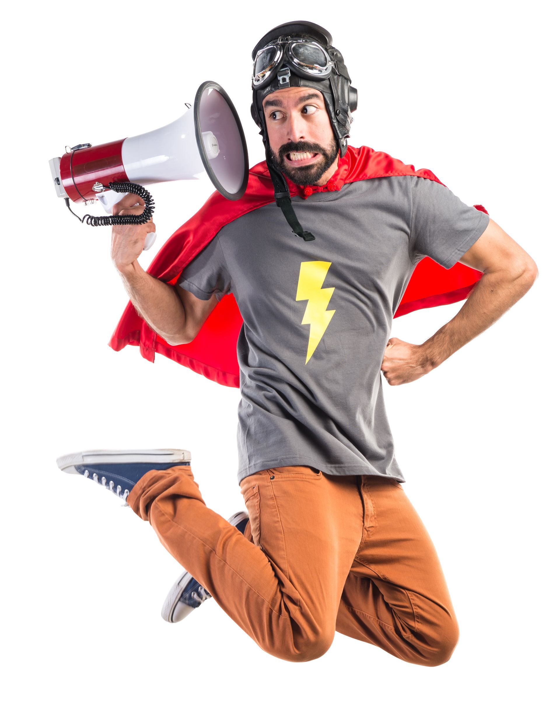 Un homme en costume de super-héros saute dans les airs tout en tenant un mégaphone.