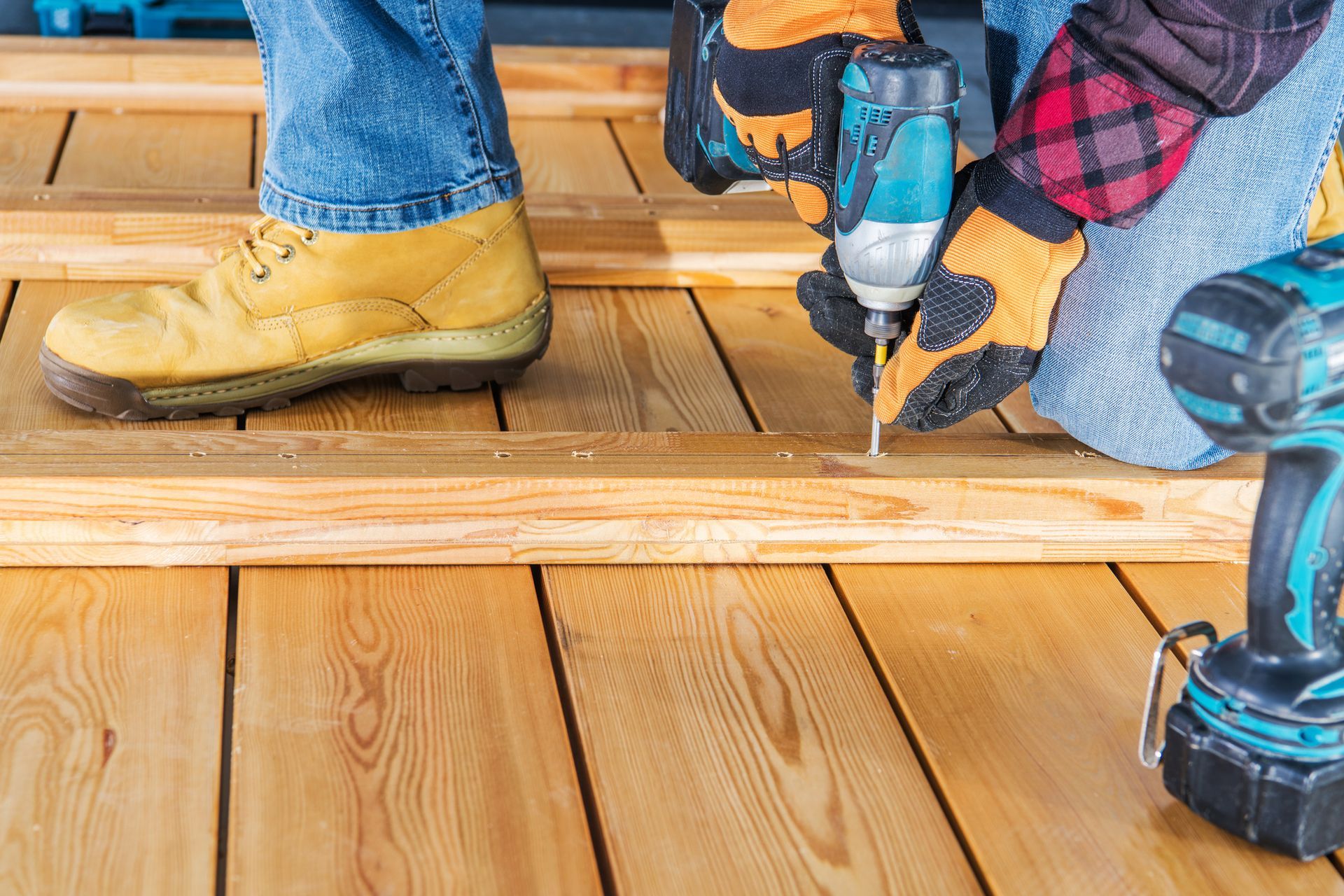 Person drilling a hole in a wood floor