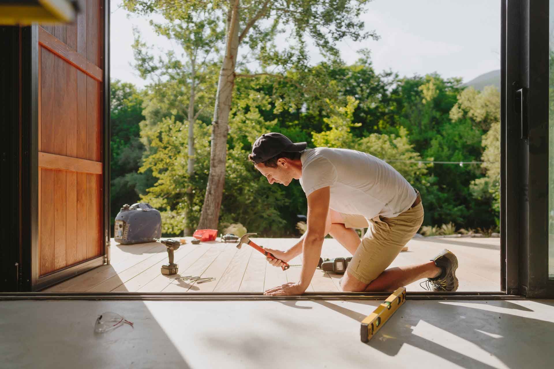 Man installing hardwood floor at home.