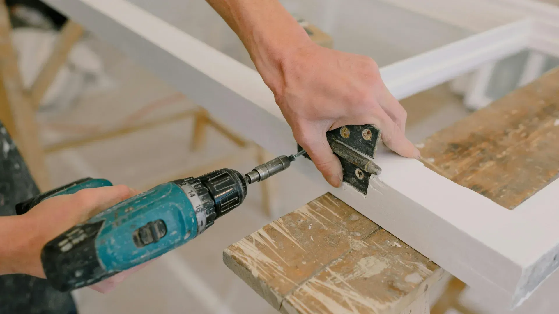 A person is using a drill on a piece of wood.