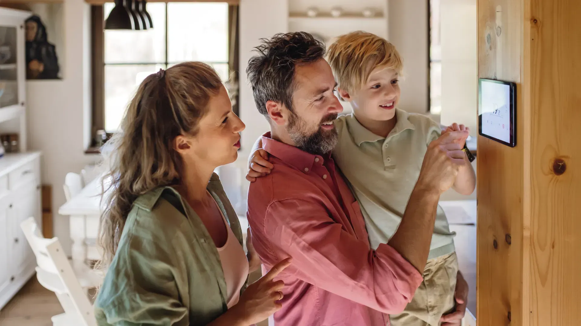 A family is looking at a tablet in a living room.