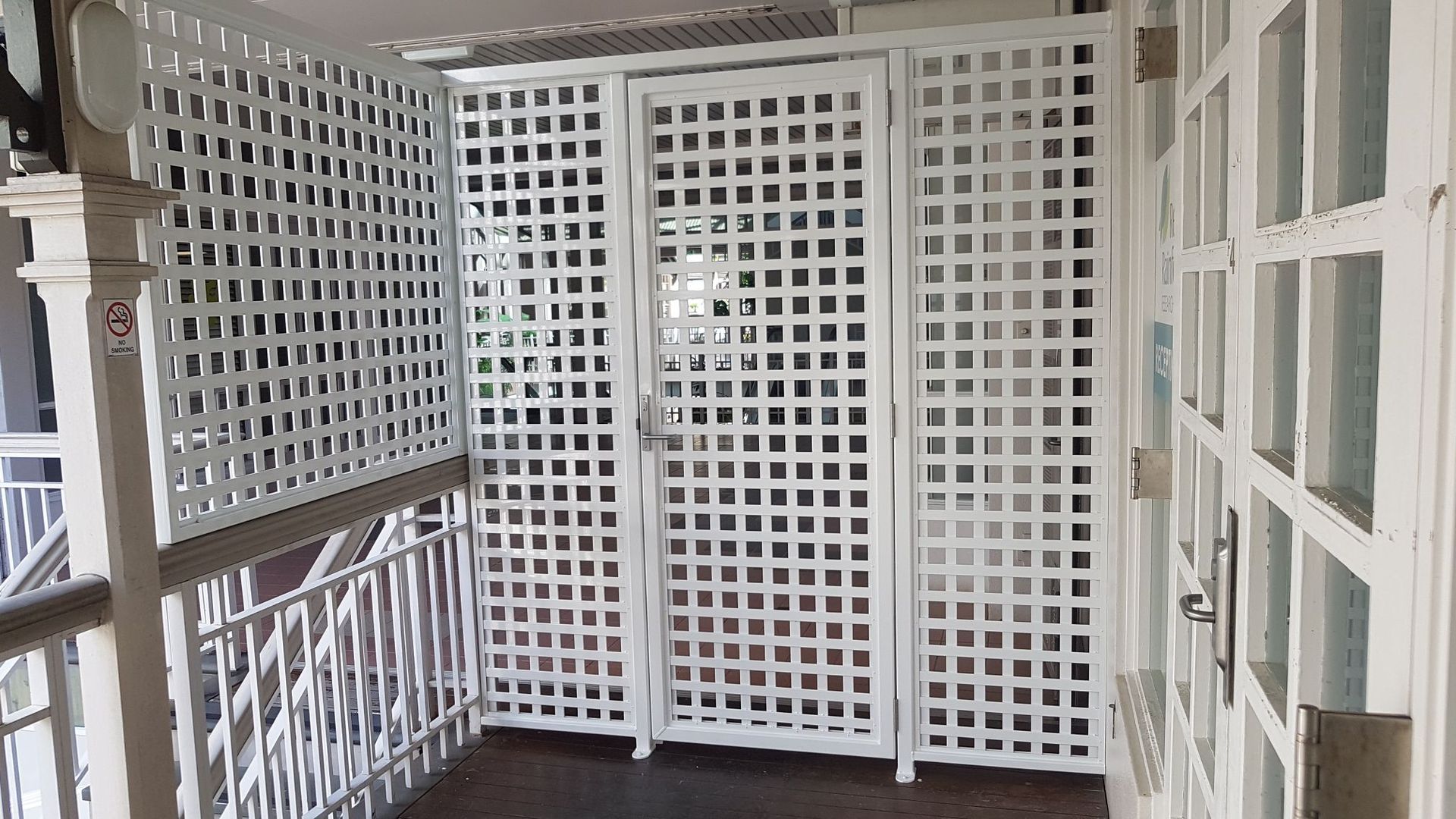 A Wooden Lattice Fence with A Door in A Warehouse  — A & B Lattice World & Patios in Bungalow, QLD