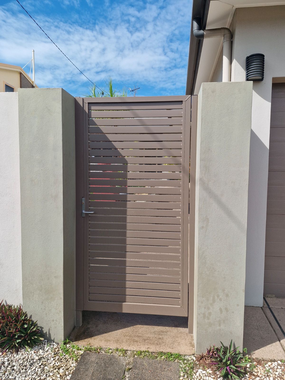 A Green Fence Is Surrounding a Window on The Side of A Building  — A & B Lattice World & Patios in Bungalow, QLD