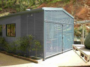 A Shed with A Fence and Shutters on The Side of It  — A & B Lattice World & Patios in Bungalow, QLD