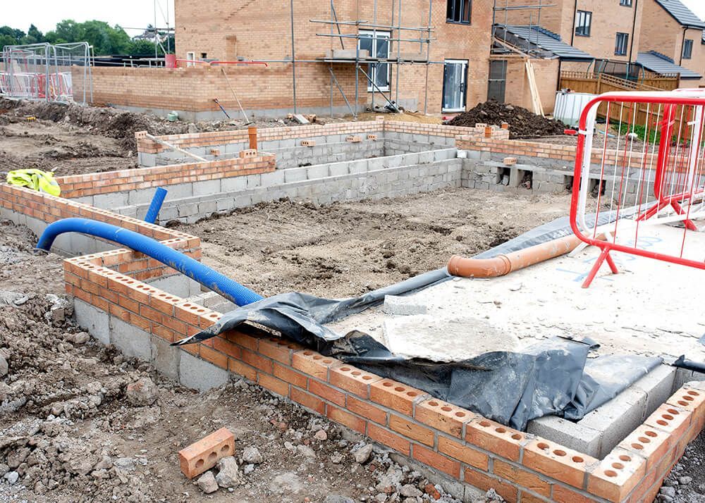a building under construction with a blue pipe sticking out of the ground